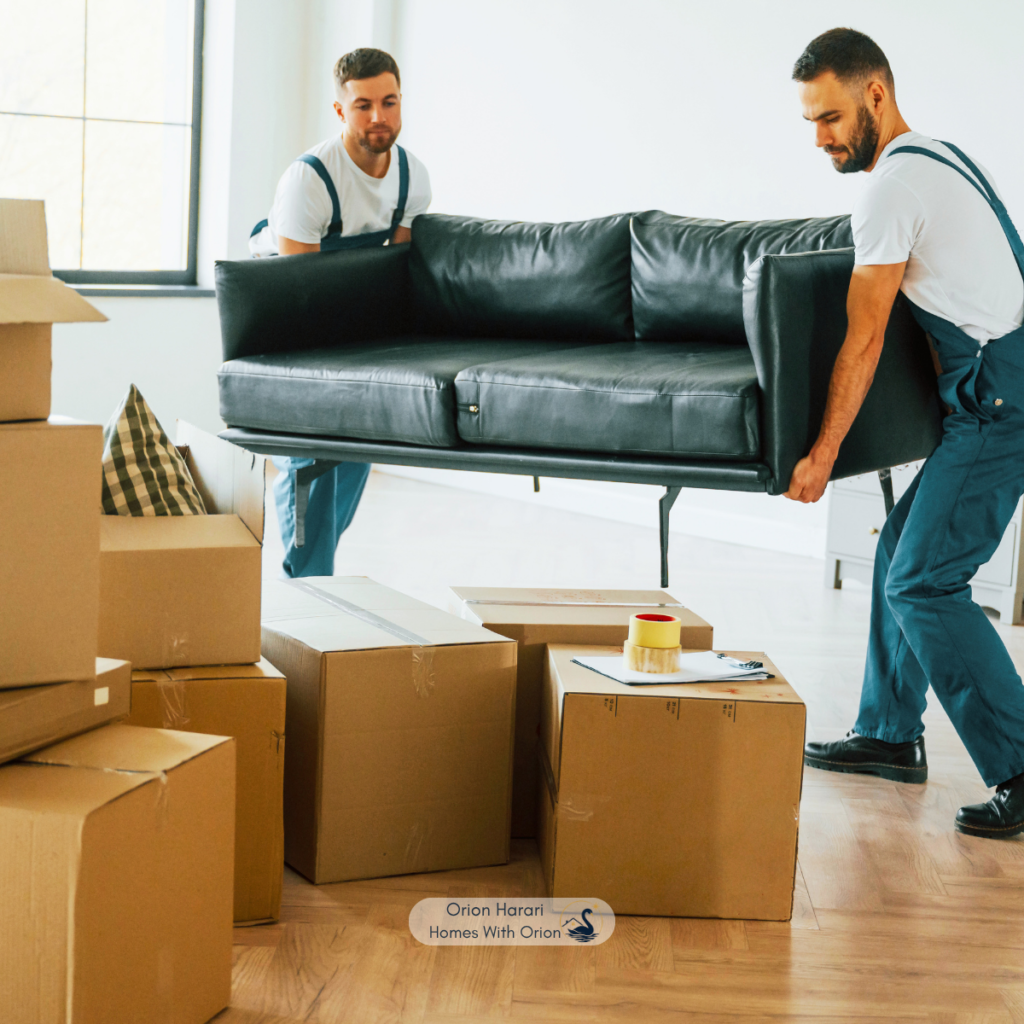 Two movers carrying furniture during a relocation to Asheville NC